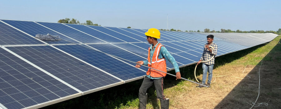FILE PHOTO: FILE PHOTO: Workers clean panels at a solar park in Modhera, India's first round-the-clock solar-powered village, in the western state of Gujarat, India, October 19, 2022. REUTERS/Sunil Kataria/File Photo